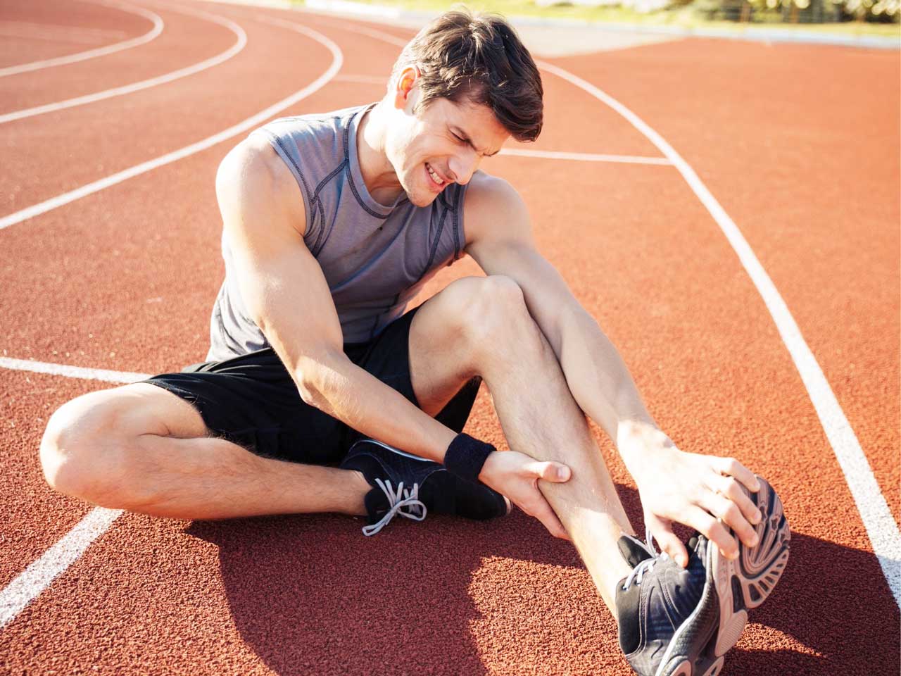 Young male runner suffering from leg cramp, Drobot dean